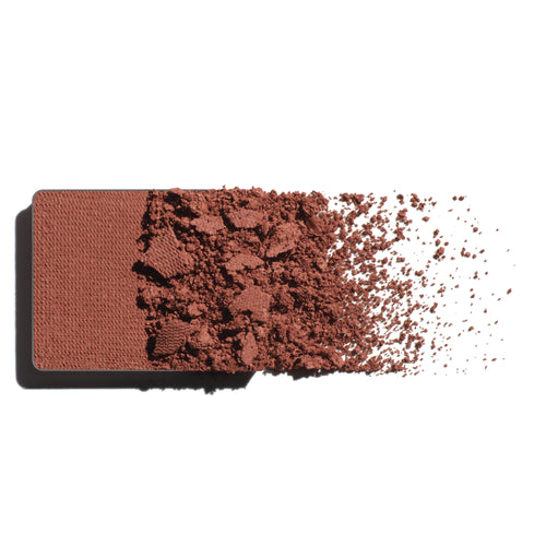 Makeup eyeshadow refill with clay pink powder on a white background