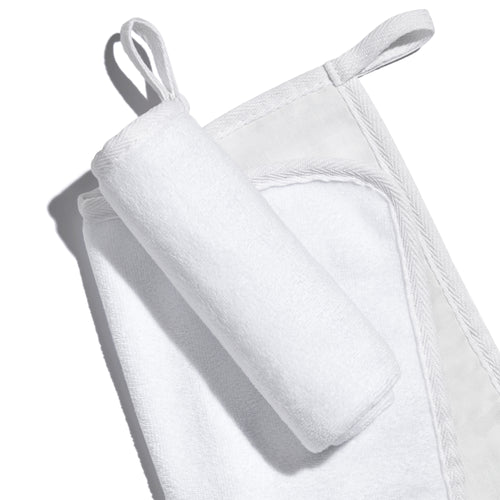 White, banded, Lisa Eldridge Luxuriously Gentle Cleansing & Exfoliating Cloth, one flat and one rolled up on top, showing different textures of the cloth faces and a loop for hanging up