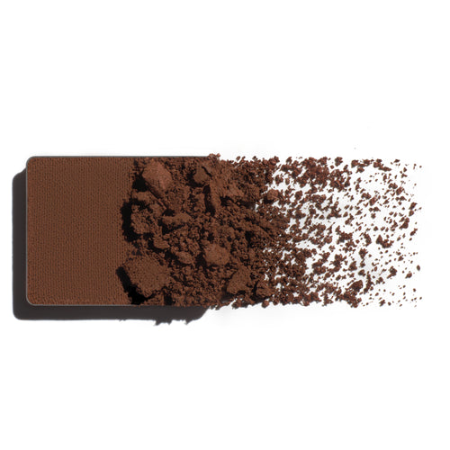 Makeup eyeshadow refill with earthy brown powder on a white background