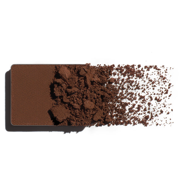Makeup eyeshadow refill with earthy brown powder on a white background