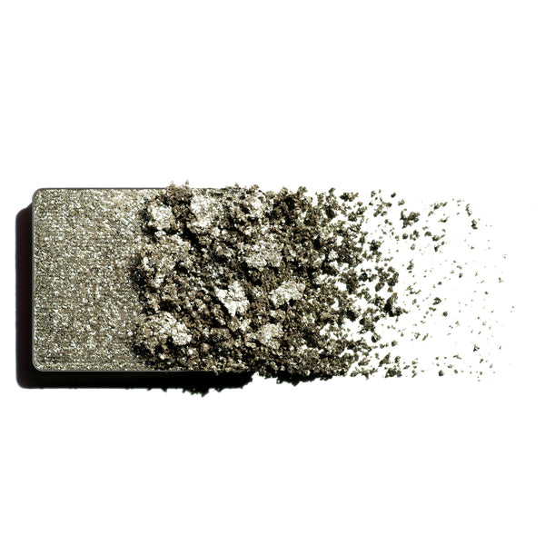 Makeup eyeshadow refill with green shimmer powder on a white background