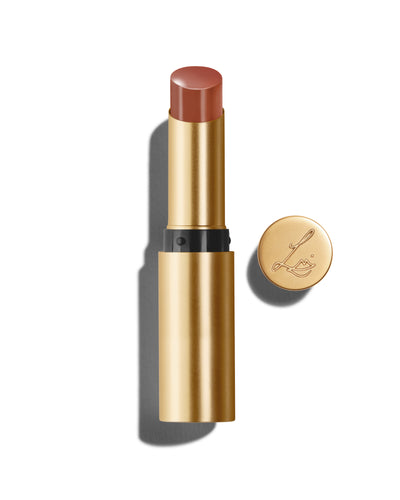 Baume Embrace in Sweet Fig, a pink-brown lip colour with a gold-colored casing, next to the Lisa Eldridge logo-embossed lid