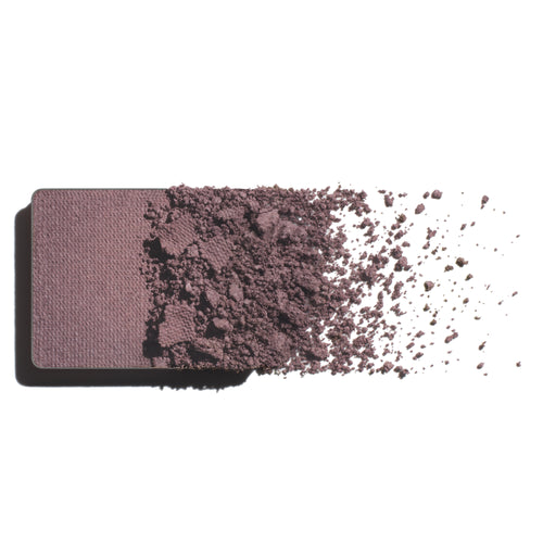 Makeup eyeshadow refill with grey lavender powder on a white background