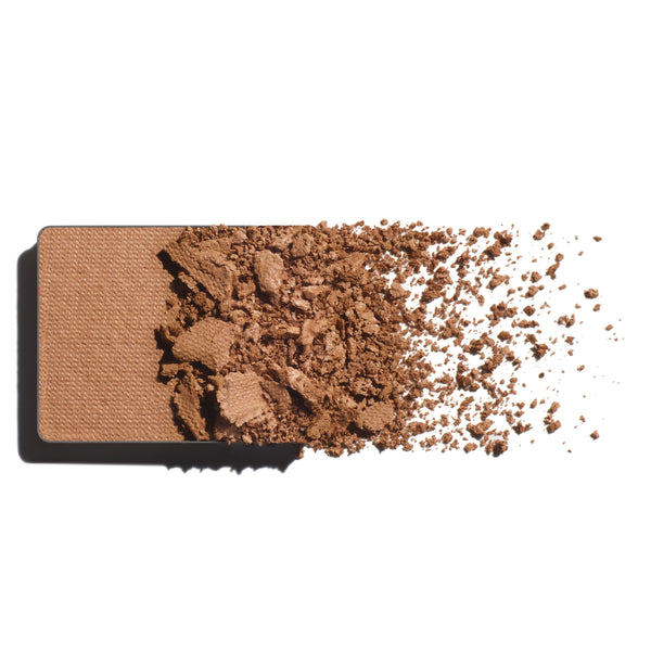 Makeup eyeshadow refill with light caramel powder on a white background