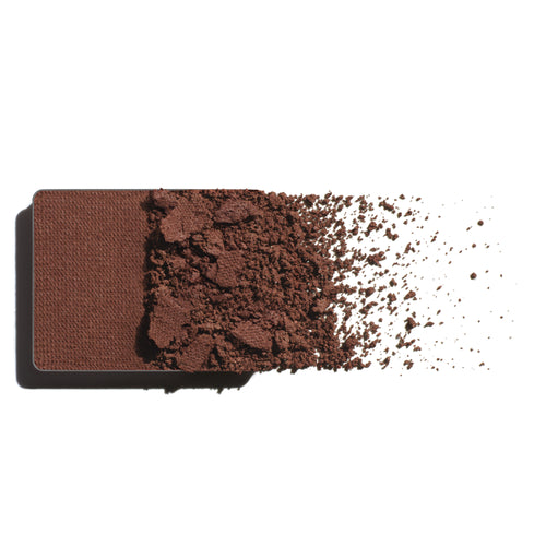 Makeup eyeshadow refill with plum brown powder on a white background